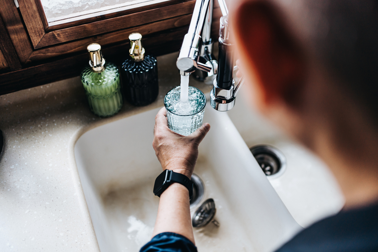 Man filling crisp filtered water at sink